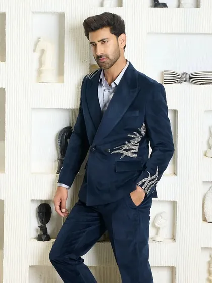 This midnight blue velvet suit offers a different take on formalwear. The double-breasted jacket is crafted from plush velvet and features striking silver embroidery on the sleeve and side.
