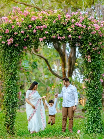 Sometimes, a simple walk in the park turns into a magical moment. We framed this beautiful family under a natural floral arch, creating a classic and elegant portrait that feels both posed and perfectly natural.