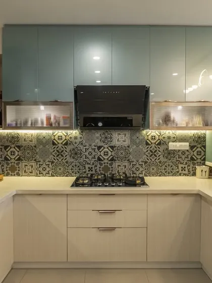 This U-shaped kitchen is a masterclass in combining color and pattern. The teal and cream cabinets provide a fresh look, while the intricate backsplash adds a touch of personality. A functional breakfast bar completes this beautiful and practical culinary space.