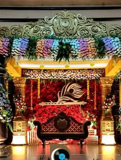 For a traditional wedding, we designed this opulent stage with intricate golden pillars, a rich red backdrop, and dense floral arrangements for a truly royal feel.