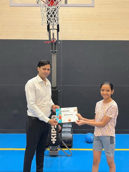 A young girl smiles as she receives her summer camp certificate. We aim to make our camps a positive and rewarding experience for all.