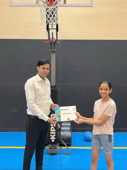 A young girl smiles as she receives her summer camp certificate. We aim to make our camps a positive and rewarding experience for all.
