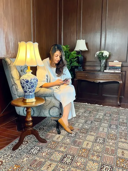 Here I am, caught in a moment of staging this cozy corner in the Maddock office. Adjusting a lamp and feeling how its light interacts with the carpet and wood paneling is a crucial part of my process. It’s in these final layers of styling that a space truly comes to life.