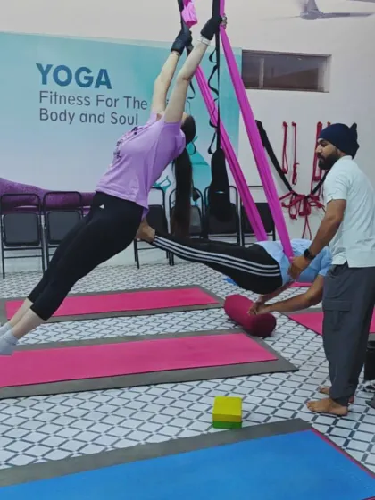 In my aerial yoga classes, I provide hands-on assistance to help you safely explore new movements. Here, I'm guiding a student into a deeper backbend using the hammock for support and alignment.