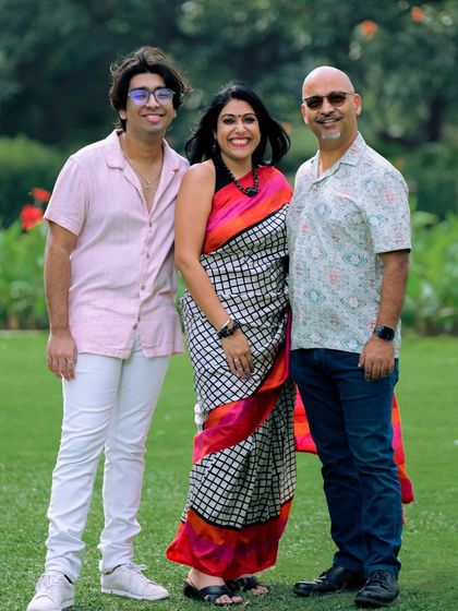 A full-length family portrait set against the backdrop of a garden. This shot showcases a happy family enjoying their time together during our session.