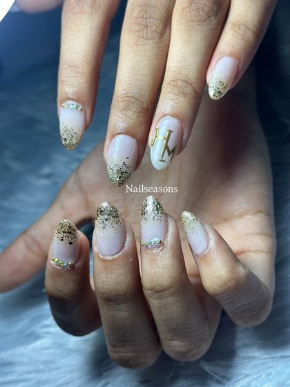 A classic bridal choice. This design features a soft nude base with a beautiful gold glitter fade and personalized initials for the couple.