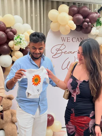 A sunflower-themed onesie being presented to the parents-to-be. It's amazing to see the different creative ideas guests come up with.