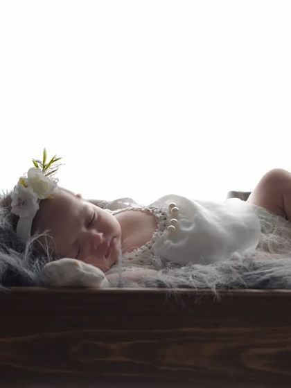 A tiny angel dreaming in a miniature wooden bed. I use a variety of props like this to create sweet, storybook scenes for your newborn's first photoshoot.