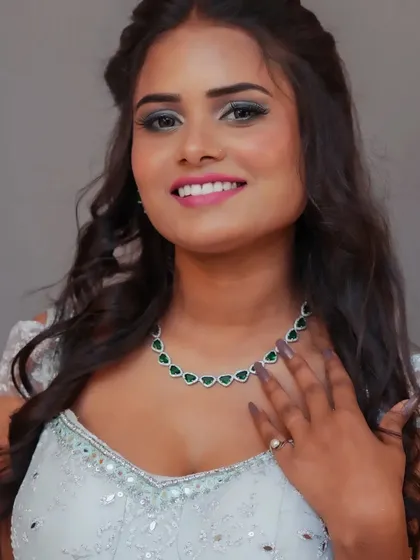 A close-up showing the beautiful green necklace paired with this light blue outfit.