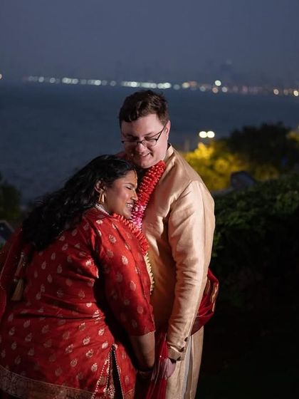 A quiet embrace between the multicultural couple, with the lights of Mumbai's Marine Drive twinkling in the background.