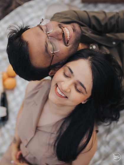 An overhead shot of a couple sharing a happy, relaxed moment during a picnic in Lonavala. This perspective offers a unique and intimate view of their connection and joy.