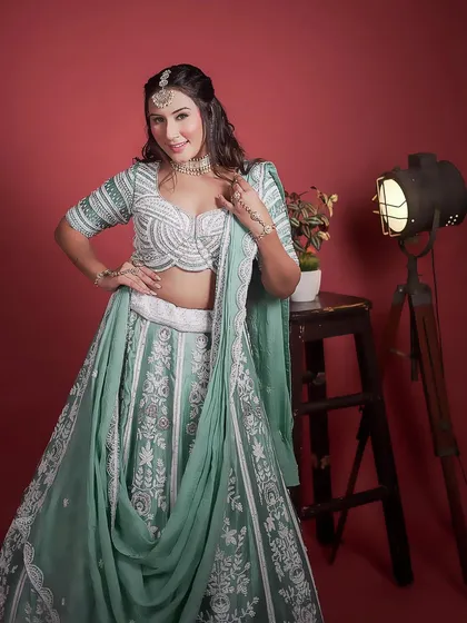 A smiling portrait in our mint green and white lehenga. The modern draped dupatta adds a stylish flair to the outfit.