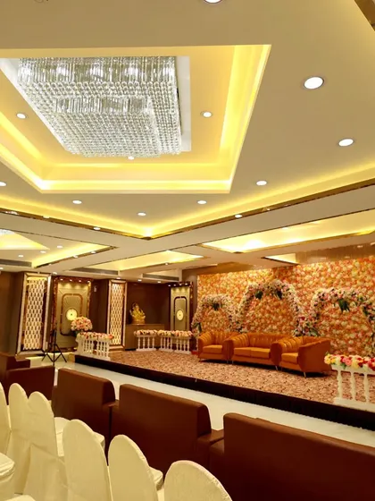 The stage and seating at Ashoka Banquet hall. The floral decor and warm lighting create an inviting atmosphere for a wedding or engagement.