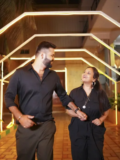 A casual and happy pre-wedding photo of the couple walking hand-in-hand through one of our lit-up sets.