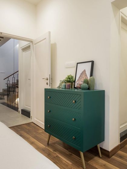 A pop of color with a teal green chest of drawers adds personality to this bedroom, proving that even functional pieces can be beautiful.