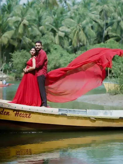A romantic pre-wedding moment captured on a boat along the serene Karavali coast. The flowing red fabric against the backdrop of coconut groves creates a cinematic feel, showcasing my style for creating beautiful, posed shots in natural settings.
