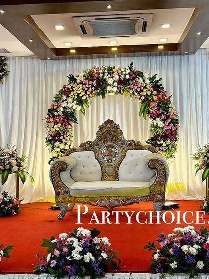 A stunning floral ring backdrop for an engagement or reception. The rich colors of the flowers against the white drapes create a beautiful focal point.