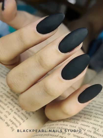 A bold and edgy set of black matte nails. The almond shape and non-reflective finish create a look that is both fierce and sophisticated.