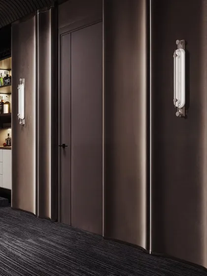 A detail shot of the entertainment room's wall treatment, featuring curved, acoustically-friendly panels and elegant wall sconces.
