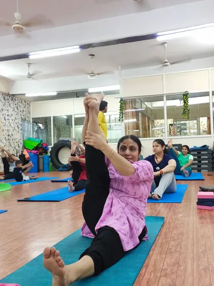 Age is no barrier to flexibility. This student demonstrates a wonderful seated leg stretch, showing the progress that is possible with consistent practice and proper guidance in our group classes.