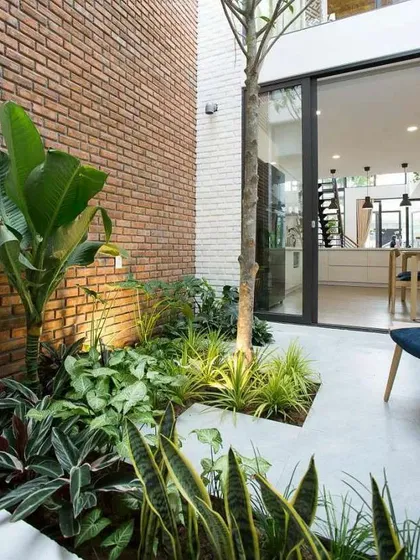 Even a small, narrow space next to a wall can become a lush indoor garden. I used a variety of shade-loving plants with different leaf textures and colors against an exposed brick wall to create a rich, tropical feel.