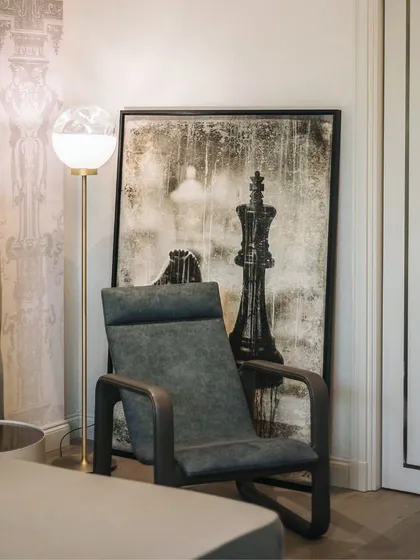 Optimistic design is an attitude. This quiet corner of a bedroom is designed for self-flourishment and contemplation. The comfortable armchair, soft lighting, and thought-provoking artwork create an upbeat and nurturing approach to living.