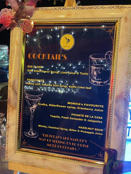 An elegant, framed cocktail menu designed for a birthday party. We can create custom names for drinks, like 'Monica's Favourite', to add a special, personal touch for the guest of honor.