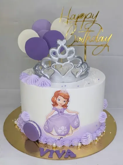 A lovely Sofia the First cake with a fresh mango flavor. This design features a silver crown, purple macarons, and balloon toppers for a royal celebration.