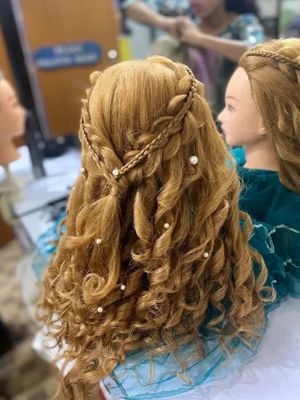 A side view of the student's work, highlighting the braided crown detail. I teach my students to create clean, professional, and long lasting styles.