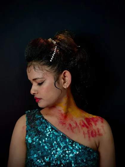 A Holi-themed look with color powder accents and a creative updo. This is a great example of creating makeup for a specific festival.