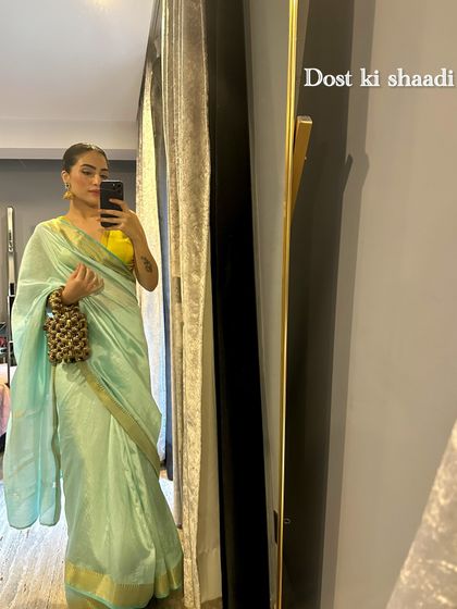 For a friend's wedding, I opted for a simple and elegant mint green Chanderi saree with a bright yellow blouse, accessorized with a beaded potli bag.