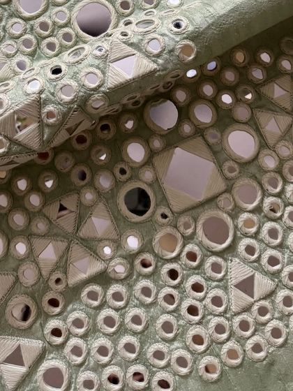 A macro shot of the mirrorwork, highlighting the precision of the embroidery.