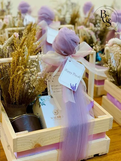 This rustic wooden crate hamper, adorned with soft purple fabric and dried flowers, is a unique take on festive gifting. It’s perfect for those who appreciate a more natural and bohemian aesthetic for their Diwali or wedding gifts.