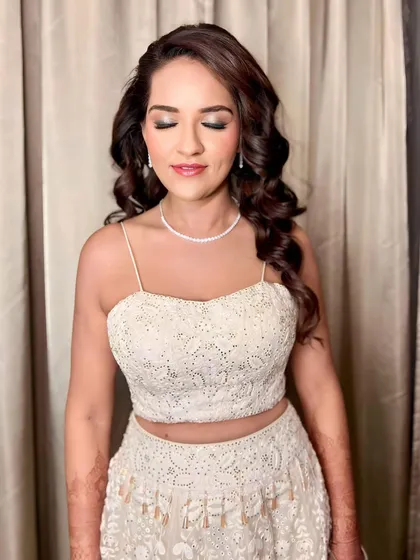 A beautiful shot of the client's soft, romantic curls for her sangeet. The makeup is focused on a shimmery eye, which pairs perfectly with the elegant hairstyle.