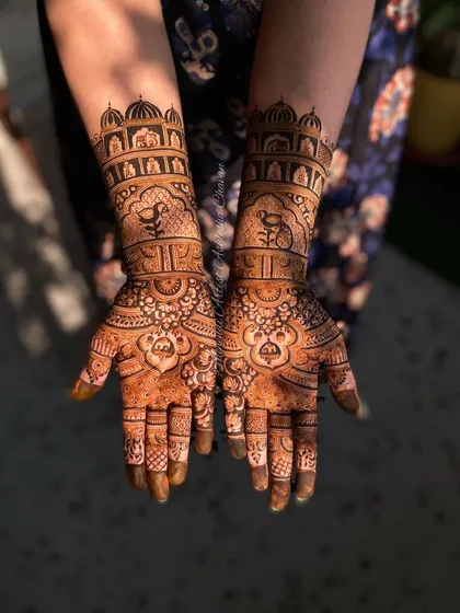 An engagement mehendi with a royal touch. The design features palace architecture and bird motifs, creating an elegant and sophisticated look.