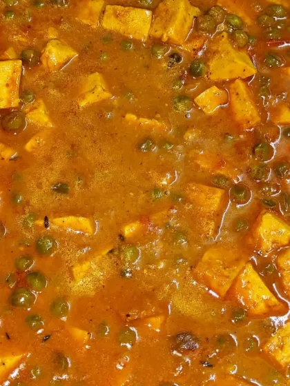 A close-up of our rich and creamy Matar Paneer curry, with soft paneer cubes and sweet peas in a flavorful gravy.