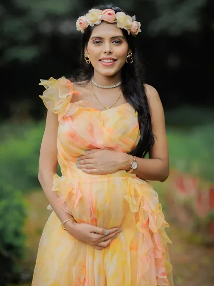 A bright and happy close-up of a mom-to-be, her smile radiating joy. The floral crown adds a perfect touch.