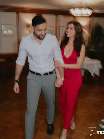 The couple walks hand-in-hand through the Soho House, sharing a look of love and excitement. This candid shot captures the happy, relaxed atmosphere of their engagement party.