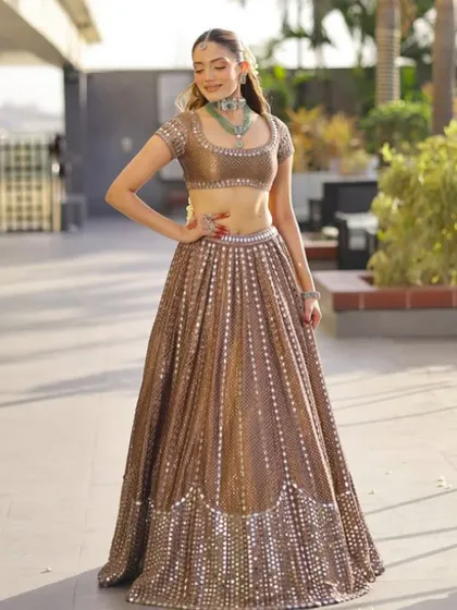 This brown lehenga with all-over mirror work is a beautiful option for a Mehendi or Sangeet ceremony. The earthy tone is unique, while the sparkle adds the perfect amount of festive glamour.