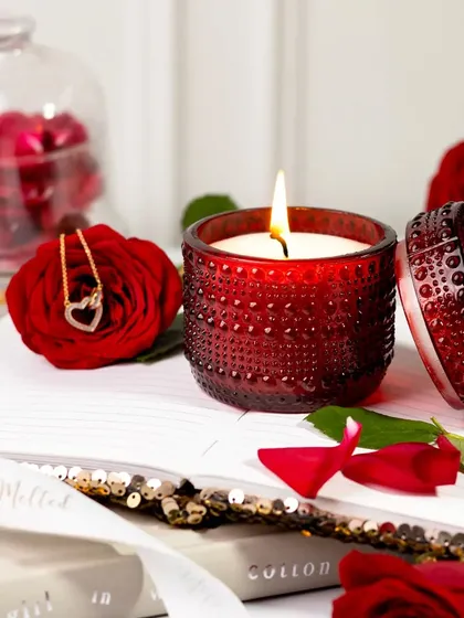 Valentine's vibes continue with this romantic scene. A striking red candle is paired with fresh roses, a delicate necklace, and an open book, creating a passionate and intimate still life.