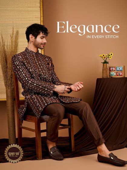 Elegance in every stitch. A model adjusts his brown patterned Indo-Western outfit, showcasing its comfortable fit and intricate design.