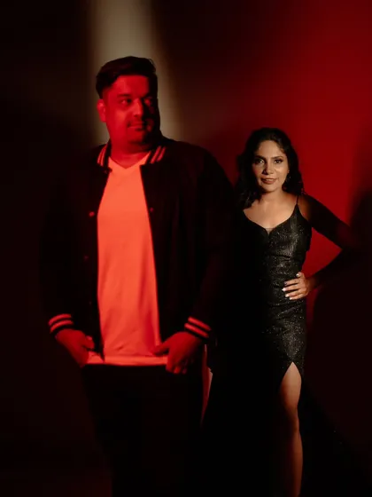 A dramatic, stylish portrait of the couple from their cocktail party. The red lighting creates a bold and edgy look.