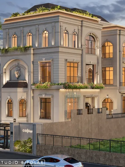 The entrance of the villa is designed to be grand and welcoming, with a large archway and planters that add a touch of greenery to the stately facade.