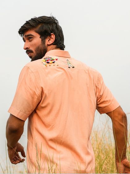 A view of the back of our camel-inspired shirt, showing the detailed embroidery on the yoke. It's a lightweight, breathable piece that echoes the resilience of the desert.
