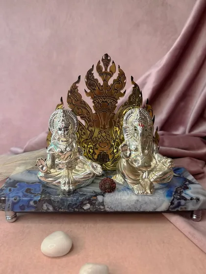 A divine setting of prosperity and auspicious beginnings. This silver-plated Ganesh and Lakshmi idol set, placed on a beautiful blue agate stone base, combines sacred energy with natural elegance for your home temple.