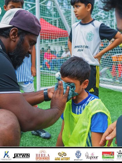 A coach tends to a player on the sidelines, showing the care and attention our staff provides.