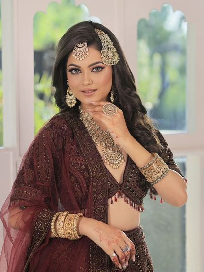 This bride's complete look showcases a heavy, antique-finish necklace, matching earrings, maang tikka, passa, and statement rings, all working together to create a stunning effect.
