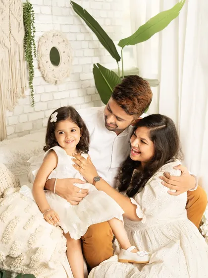 The best family photos are often the unscripted ones. This candid shot captures pure joy and laughter in a modern, light-filled setting. Coordinated white outfits give the session a fresh and contemporary feel, perfect for remembering these playful family moments.