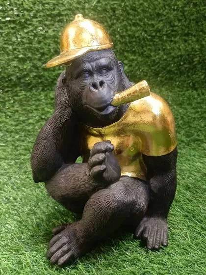 This cool chimpanzee showpiece with a golden shirt and cap is a quirky and modern decor item.