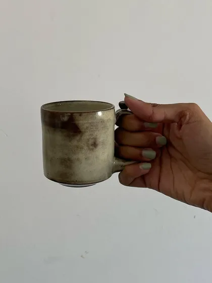 A collection of my handmade ceramic mugs, each with its own unique shape and glaze. The little coffee bean detail on the handle is a fun touch for coffee lovers.